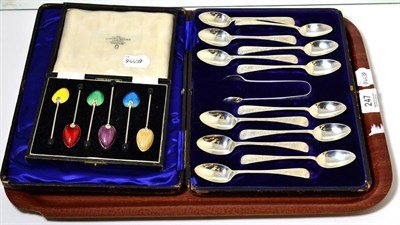 Lot 247 - A cased set of six enamelled silver coffee bean spoons and a cased set of twelve silver tea...