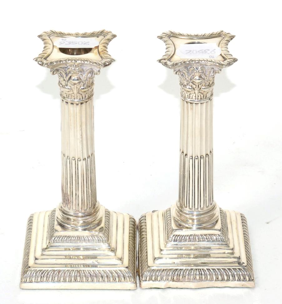 Lot 290 - An Edwardian pair of silver Corinthian column candlesticks, by Hutton & Co Ltd London, 1910,...