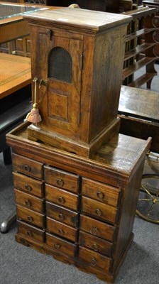 Lot 1197 - A reproduction hardwood fifteen drawer chest and a hardwood bedside cupboard