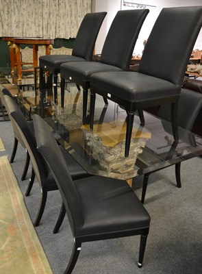 Lot 1211 - A glass top dining table, modern, of canted rectangular form with bevelled edge, raised on a...