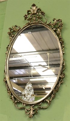 Lot 1235 - A silvered carved wooden oval mirror