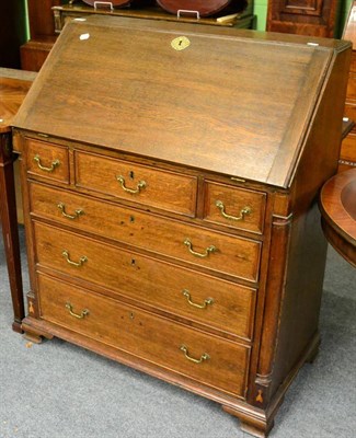 Lot 1287 - A George III oak bureau, the drawers flanked by quarter columns