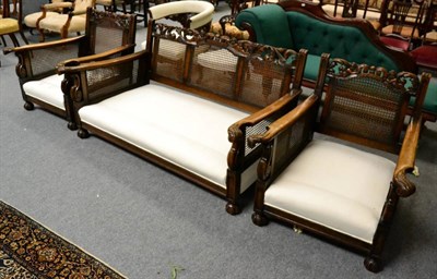 Lot 1297 - A 1920's carved oak three piece bergere suite