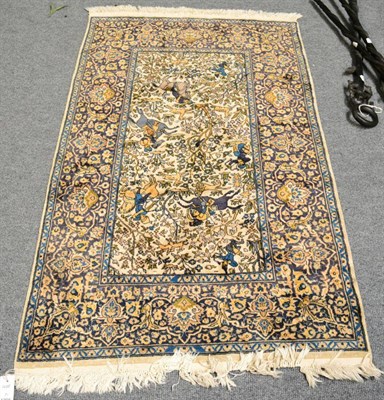 Lot 1298 - An Indian rug, depicting a hunting scene, the ivory field with huntsman in a wooded landscape...