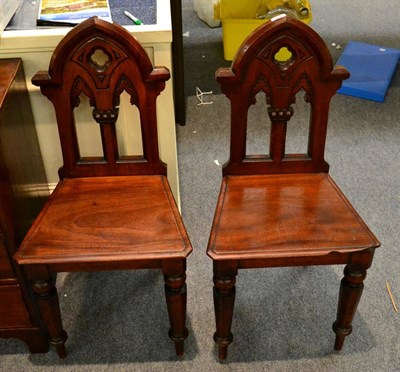 Lot 1306 - A pair of Victorian mahogany hall chairs with pierced Gothic backs