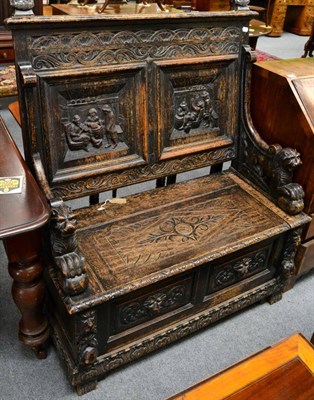 Lot 1328 - A carved oak box settle decorated with interior tavern scenes