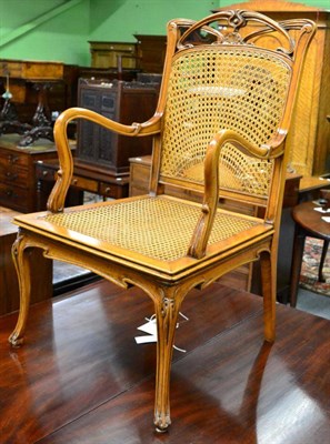 Lot 1332 - An Art Nouveau style armchair with cane back and seat