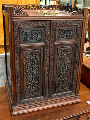 Lot 1340 - A Chinese carved hardwood two door cabinet