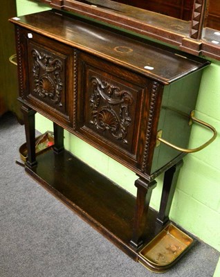 Lot 1366 - A carved oak low hall cupboard fitted with twin umbrella stands