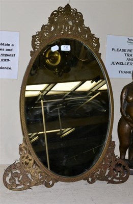 Lot 139 - A 19th century dressing mirror in a pierced and foliate engraved brass frame, with easel back