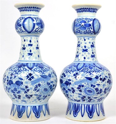 Lot 196 - A near pair of Delft blue and white guglet form bottle vases, in the 18th century style, bird...