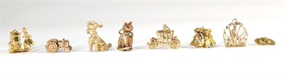 Lot 233 - Eight various 9 carat gold charms, including; a poodle, a cat, a classic car, an elephant, a...