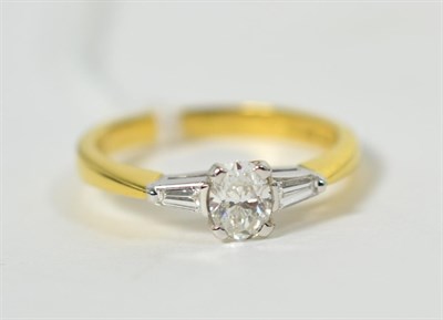 Lot 269 - An 18 carat gold diamond ring, an oval cut diamond to tapered baguette cut diamond set...