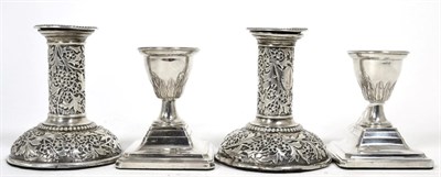 Lot 282 - A pair of Victorian silver candlesticks decorated with foliage and flowers; together with a further