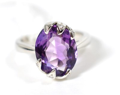 Lot 322 - An 18 carat white gold amethyst and diamond ring, an oval cut amethyst in a fancy diamond set...