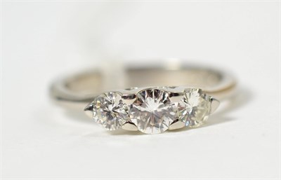 Lot 329 - A platinum diamond three stone ring, graduated round brilliant cut diamonds in claw settings, total