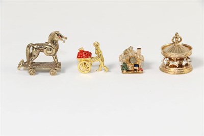 Lot 332 - Four 9 carat gold and enamel charms, including; a carousel charm, a log cabin Stanhope viewer,...