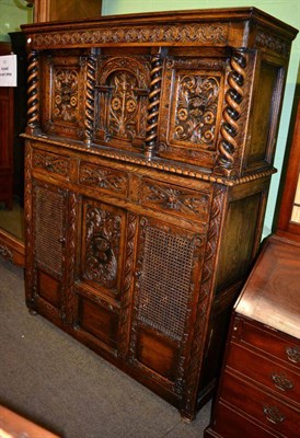 Lot 1203 - A reproduction oak carved court cupboard