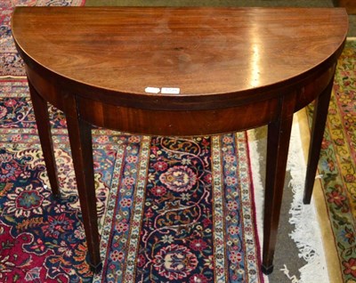 Lot 1239 - A George III mahogany demi lune fold over tea table