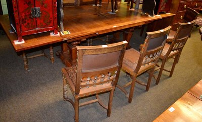 Lot 1294 - A French oak draw leaf dining table with eight embossed leather dining chairs