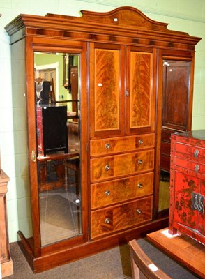 Lot 1307 - An early 20th century mahogany triple wardrobe, two doors with four drawers below