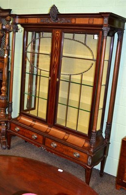 Lot 1317 - An impressive Edwardian inlaid mahogany display cabinet, the inverted breakfront cornice above...