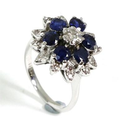 Lot 60 - A sapphire and diamond cluster ring, a round brilliant cut diamond within a border of round cut...