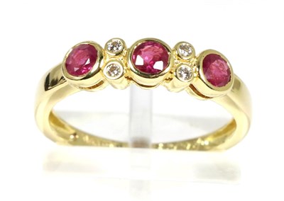 Lot 75 - An 18 carat gold ruby and diamond ring, three round cut rubies in rubbed over settings, spaced...