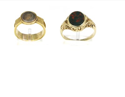 Lot 239 - A bloodstone signet ring, an oval bloodstone plaque in a rubbed over setting, to heavily carved...