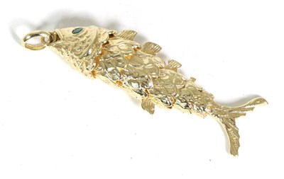 Lot 240 - A 9 carat gold articulated fish pendant, with round cut emerald set eyes, 6.5cm long