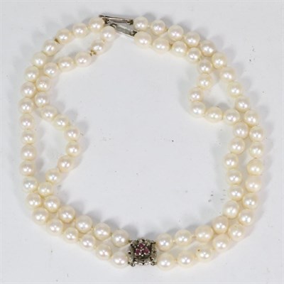 Lot 242 - A double strand cultured pearl necklace with a 9 carat white gold ruby cluster clasp, length 38cm