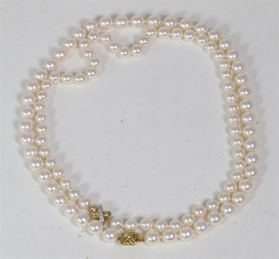 Lot 252 - A cultured Akoya pearl necklace, uniform pearls knotted to a diamond set X-shaped clasp,...