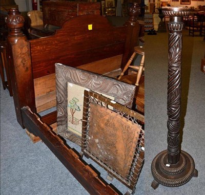 Lot 1188 - A carved mahogany bedstead, two fire screens, one with a needlework panel, the other tooled...