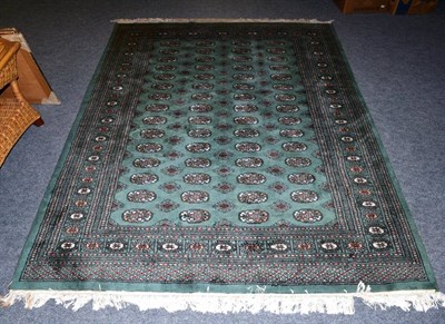 Lot 1214 - A Pakistani Bokhara rug, the mint green field with columns of quartered guls, enclosed by...