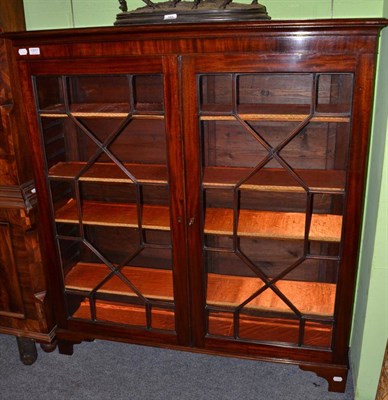 Lot 1317 - An early 20th century mahogany glazed bookcase with four adjustable shelves