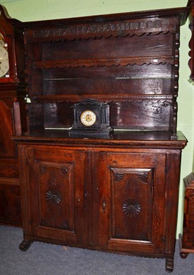 Lot 1318 - A 19th century continental oak dresser, with bold canopy above a carved frieze with initials...