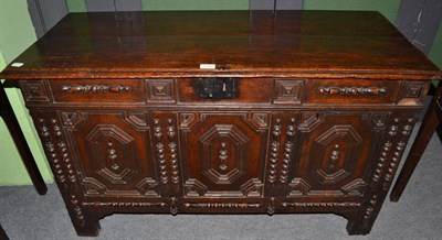 Lot 1322 - A 17th century joined oak coffer, with hinged lid above three geometric moulded panels with applied