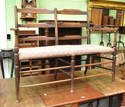 Lot 1338 - A ladder back two seat settee