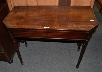 Lot 1350 - A mahogany folding games table on turned legs