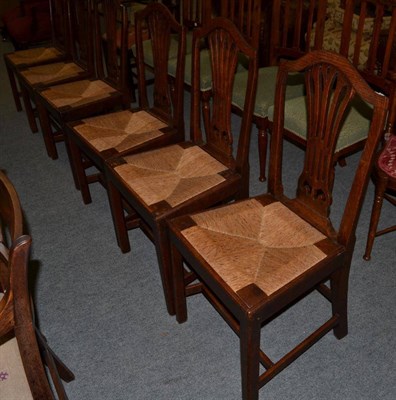 Lot 1370 - A set of six George III oak dining chairs, with pierced splat and drop in rush seat