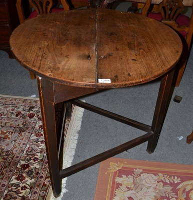 Lot 1384 - An early 19th century elm and oak circular cricket table, the two piece top raised on...