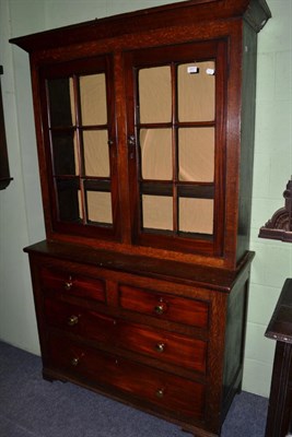 Lot 1417 - An oak bookcase, the upper section with a pair of glazed doors, above two short and two long...