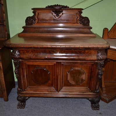 Lot 1423 - A 19th century continental walnut sideboard or serving cabinet, with carved pediment above a staged