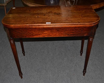 Lot 1428 - A D shaped mahogany fold over tea table on turned supports