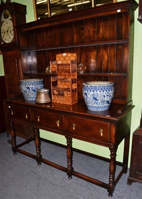 Lot 1438 - An oak dresser and rack, the base fitted with three short drawers, on turned supports, joined...