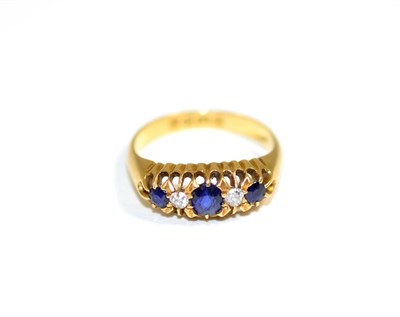 Lot 134 - An 18 carat gold sapphire and diamond ring, three graduated oval cut sapphires spaced by old...
