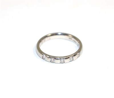Lot 149 - A platinum diamond ring, channel set with five round brilliant cut diamonds, total estimated...