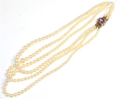 Lot 155 - A cultured pearl necklace, with an amethyst and pear set clasp, three strands of graduated cultured