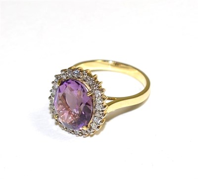 Lot 158 - An amethyst and diamond cluster ring, an oval cut amethyst in a claw setting, within a border...
