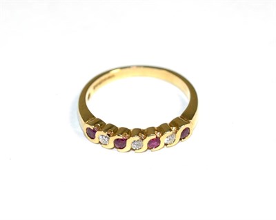 Lot 173 - A 9 carat gold ruby and diamond half hoop ring, total estimated diamond weight 0.15 carat...